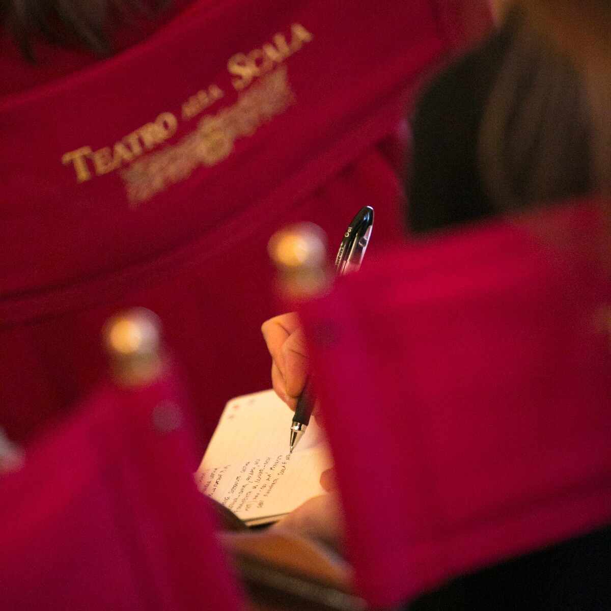 detail of a person taking notes in a notebook