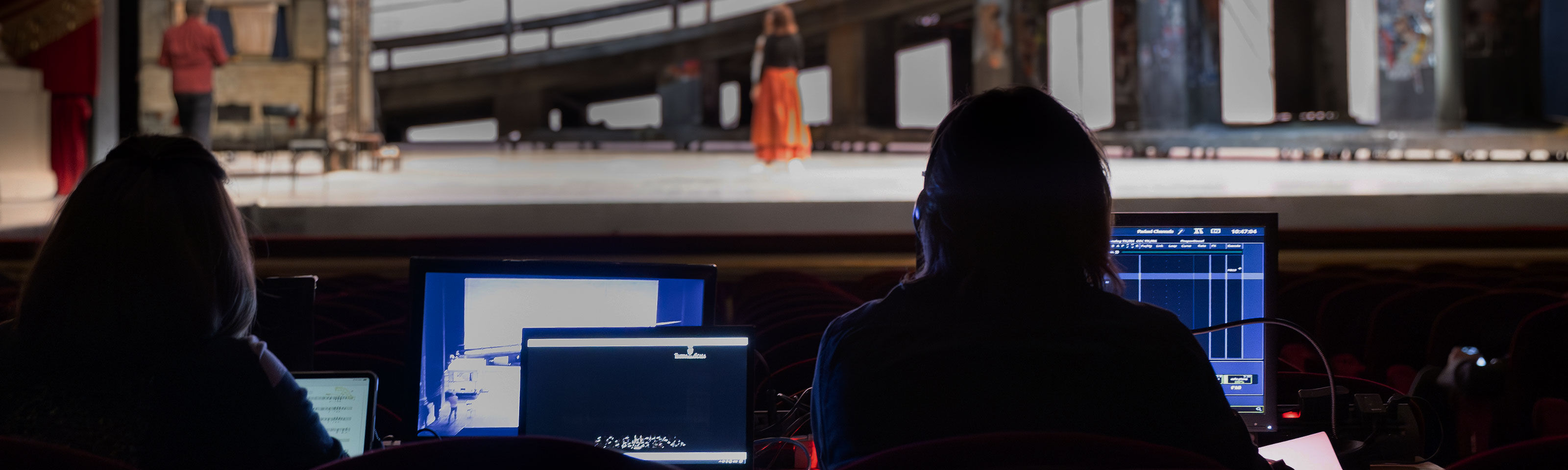 una postazione di regia all'interno della sala di un teatro durante la produzione