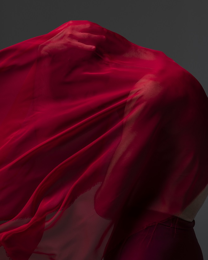 Uno scatto di federica capo dove predomina il colore rosso: due ballerini si nascondono dietro a un velo di tulle cremisi